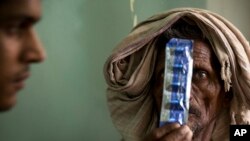 A tuberculosis patient holds medicines at the Lal Bahadur Shastri Government Hospital at Ram Nagar in Varanasi, India, March 13, 2018.