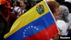 Un manifestante sostiene una bandera venezolana mientras la gente se reúne para protestar por los resultados electorales que otorgaron al presidente de Venezuela, Nicolás Maduro, un tercer mandato, en Caracas, Venezuela, el 30 de julio de 2024.