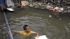 A Thai boy plays at a flooded area in Bangkok, Thailand. Hundreds of people have died across Southeast Asia, China, Japan and South Asia in the last four months from prolonged monsoon flooding, typhoons and storms, October 3, 2011.