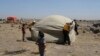 This photo, released by the Syrian Civil Defense White Helmets, shows civil defense workers setting up a tent for civilians who fled from Daraa after shelling by Syrian government forces, in the town of Qunaitra, southwestern Syria, June 28, 2018.