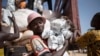 FILE - A man carries packages of food aid delivered by the U.N. Office for the Coordination of Humanitarian Affairs and World Food Program in Makunzi Wali, Central African Republic, April 27, 2017.