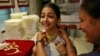 Girl tries on gold necklace inside a jewelry showroom in Mumbai, April 16, 2013.