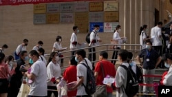 ARCHIVO - Estudiantes se forman para entrar a una escuela en el primer día de los exámenes de ingreso a la educación superior de China, conocido como el goakao, en Beijing, el martes 7 de junio de 2022.