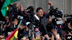 Presiden Bolivia Luis Arce mengepalkan tangan dikelilingi oleh para pendukung dan media, di luar istana pemerintah di ibu kota La Paz, pasca upaya kudeta yang gagal (26/6). 