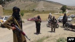 FILE - Fighters with Afghanistan's Taliban militia stand with their weapons in Ahmad Aba district on the outskirts of Gardez, the capital of Paktia province, July 18, 2017.