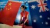 FILE - A stewardess arranges documents before a seminar of Australia China bilateral cooperation in resources and infrastructure in West Australia, in Beijing.