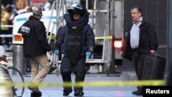 Un miembro del escuadrón de desactivación de bombas del departamento de Policía de Nueva York revisa los alrededores del edificio Time Warner en el centro de Manhattan. 