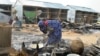 A woman salvages cooking pots at the site of an explosion in Maiduguri, Nigeria, June 8, 2017. Authorities in northeast Nigeria say at least 14 people are dead and dozens are wounded after Boko Haram militants launched a series of attacks.