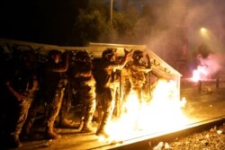 Bombas caseras son lanzadas por manifestantes antigubernamentales contra soldados libaneses en una protesta contra las élites políticas y la corrupción luego de la explosión en el puerto de Beirut que devastó gran parte de la ciudad. Agosto 6, 2020.