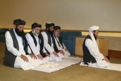 La delegación talibán de Afganistán reza antes de la firma del acuerdo entre talibanes y funcionarios estadounidenses en Doha, Catar, el sábado 29 de febrero de 2020.