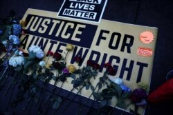 Un cartel lleno de flores pide justicia para Dante Wright frente al Departamento de la Policía de Brooklyn Center, Minnesota, el 13 de abril de 2021.