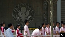 Estudiantes chinos aguardan frente a la embajada de EE.UU. en Beijing para solicitar visas.