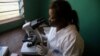 FILE - A laboratory worker uses a microscope at the health center in the commune of Wangata during a vaccination campaign against the outbreak of Ebola, in Mbandaka, Democratic Republic of the Congo, May 23, 2018. 