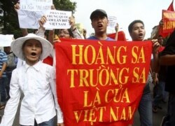 FILE - Vietnamese protesters carry a banner with a Vietnamese slogan reading, "Paracel islands and Spratly islands belong to Vietnam," during a protest demanding China to stay out of their waters around the Spratly Islands.