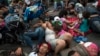 Members of a US-bound migrant caravan rest on a road between the Mexican states of Chiapas and Oaxaca after federal police briefly blocked them outside the town of Arriaga, Oct. 27, 2018. 