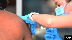 ARCHIVO - Personal sanitario inyecta una vacuna contra COVID-19 en un centro de vacunación para personas sin hogar el 22 de septiembre de 2021, en Los Ángeles, California. 