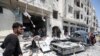 FILE - Syrians gather at a site of car bomb in the northwestern Syrian city of Idlib, Aug. 2, 2018. U.N. reports an upsurge in aerial and ground-based bombardment by Syrian and Russian forces over the past week has killed scores of civilians and displaced more than 30,000 women, children and men within the region.