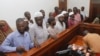Murder suspects in the killing of Ugandan Police Commander Andrew Felix Kaweesi stand behind the dock at the Nakawa Chief Magistrates court in Kampala, Uganda, May 18, 2017. (H. Athumani/VOA)
