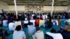 FILE - Migrants attend prayers at a detention center in Tripoli, Libya, June 15, 2018.