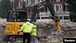 Workers react after the 1887 time capsule was removed from the former Robert E. Lee monument in Richmond, Virginia, Dec. 27, 2021. 