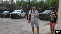 Turistas y policías se observan en el exterior del hotel Hyatt Ziva Riviera en Puerto Morelos, Quintana Roo, México, después de un tiroteo en la playa que dejó dos muertos el 4 de noviembre de 2021.