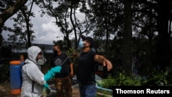Un hombre en El Salvador es rociado con un líquido desinfectante, una de las medidas tomadas por las autoridades para frenar la propagación del COVID-19. 2 de junio de 2020.