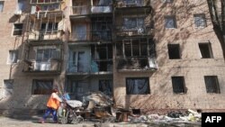Una mujer camina junto a un edificio dañado por los ataques ucranianos en Kursk el 16 de agosto de 2024, luego de la ofensiva de Ucrania en la región occidental de Kursk en Rusia.