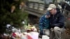 David Freedman, right, kneels with his son Zachary, 9, as they visit a sidewalk memorial for the 26 people, including 20 children, who were killed at Sandy Hook Elementary School in Newtown, Connecticut, December 16, 2013. 