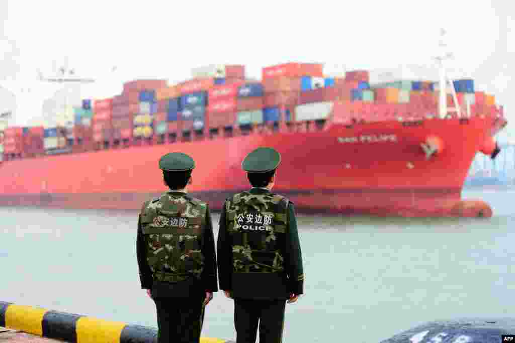2018年3月8日,中国警察在中国东部山东省青岛港口观察一艘货船。