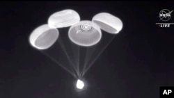 Imagen divulgada por la NASA de la cápsula Crew Dragon de SpaceX cuando descendía con cuatro astronautas en el Golfo de México el 8 de noviembre de 2021.