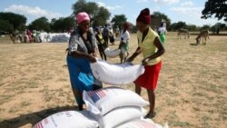 Villagers queue to collect their monthly food aid ration of cereals at a school in drought hit Masvingo, Zimbabwe, June 2, 2016.