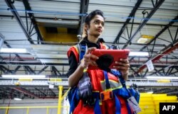A woman uses a computer to control robots at the 855,000-square-foot Amazon fulfillment center in Staten Island, one of the five boroughs of New York City, Feb. 5, 2019.