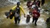 Un grupo de migrantes de Venezuela, Ecuador y Haití, cruzan el Río Muerto en la Selva del Darién, entre Colombia y Panamá, el 9 de Julio de 2023.
