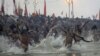 Indian Hindu holy men run naked into the water at Sangam, the confluence of the rivers Ganges, Yamuna and mythical Saraswati, during the royal bath at the start of the Kumbh Mela in Allahabad, India, Janaury 14, 2013.