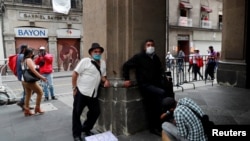 A un hombre le lustran los zapatos cerca de la plaza Zócalo, en la Ciudad de México. 31 de julio de 2020.