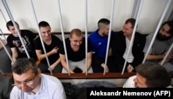 RUSSIA -- Ukrainian sailors sit inside a defendants' cage prior during a hearing at a court in Moscow, July 17, 2019