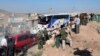 Photo released by the Syrian official news agency SANA shows Syrian troops, journalists, and civilians watching as buses evacuate people from the two pro-government villages of Foua and Kfarya, at Tel el-Eis, the crossing between Aleppo and Idlib provinces, Syria, July 19, 2018.