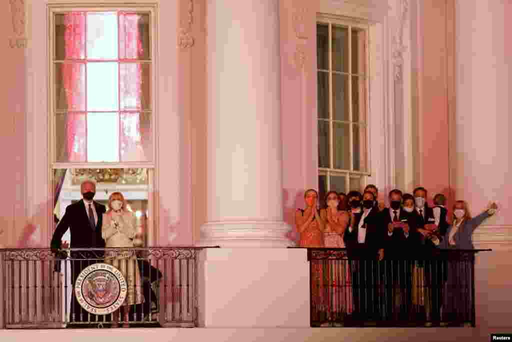 El presidente Joe Biden y la primera dama Jill Biden se asoman al balc&#243;n de la Casa Blanca, ante la atenta mirada de sus familiares durante la celebraci&#243;n. 20 de enero de 2021.