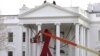 A large red ribbon is installed on the North Portico of the White House to mark World AIDS Day on December 1, in Washington, D.C., November 30, 2012.