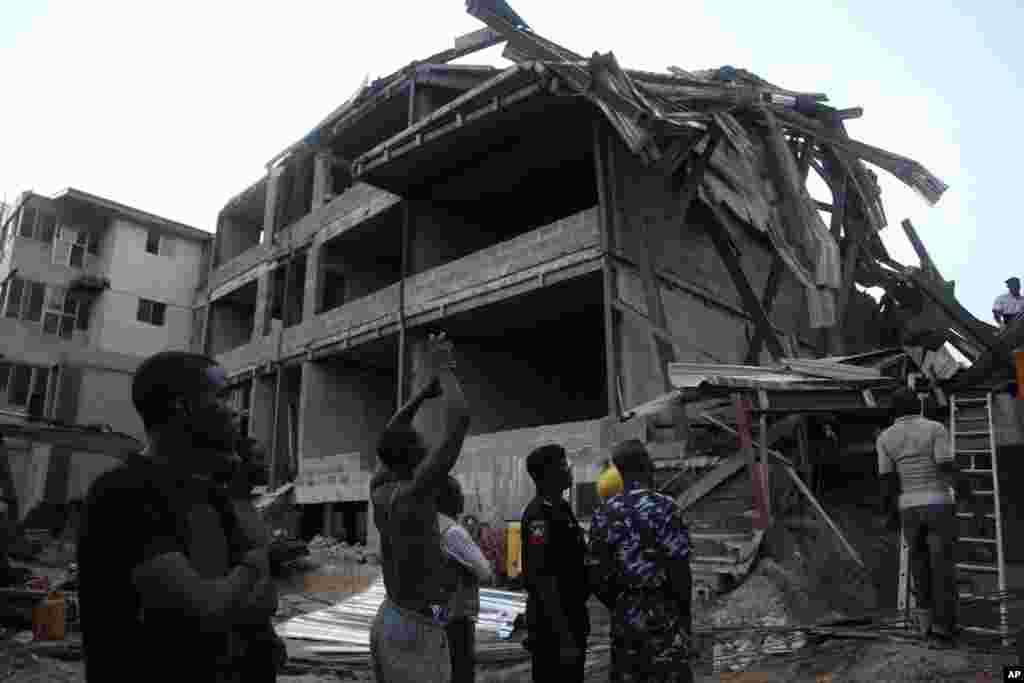 Police officers, rescue workers and onlookers gather near the site of a building under construction which collapsed in Lagos, Nigeria, Nov, 4. 2013.