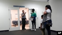 Un agente recibe a personas en un tribunal, el 10 de enero de 2024, en una corte de inmigración de Miami. 