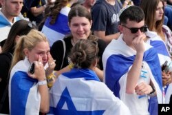 La gente asiste a una ceremonia en el antiguo campo de exterminio nazi de Auschwitz-Birkenau durante el evento anual de conmemoración del Holocausto en memoria de los seis millones de víctimas del Holocausto en Oswiecim, Polonia, el lunes 6 de mayo de 2024.