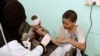 A doctor treats children injured by an airstrike in Saada, Yemen Aug. 9, 2018.