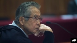 El expresidente de Perú Alberto Fujimori, es fotografiado a través de una ventana de vidrio, mientras asiste a su juicio en una base policial en las afueras de Lima, Perú, el 28 de junio de 2016. Archivo.