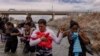ARCHIVO - Yusniel, un migrante de Cuba, sostiene a su hijo de 10 días, Yireht, y a su esposa, Yanara, mientras buscan un punto de entrada más allá de una cerca de alambre a lo largo de la orilla del río Grande en Eagle Pass, Texas, EEUU, el 6 de octubre de 2023.