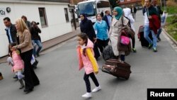 FILE - Syrian refugees arrive at the camp for refugees and migrants in Friedland, Germany, April 4, 2016.