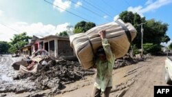 Un residente local, víctima de las tormentas tropicales Eta e Iota, lleva un colchón a lo largo de una calle cubierta de barro en la comunidad de Flores de Oriente, municipio de La Lima, departamento de Cortés, Honduras 15 de diciembre de 2020.