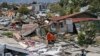 Rescuers carry a body bag containing the remains of an earthquake victim through a neighborhood flattened by Friday's earthquake in Palu, Central Sulawesi, Indonesia, Oct. 2, 2018. 