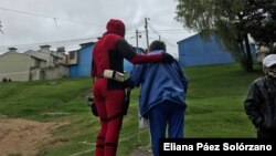 Uno de esos héroes ayuda a una mujer mayor a caminar. [Foto: Eliana Paola Páez Solórzano]