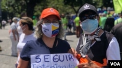 Manifestantes sostienen un cartel donde se lee "seguir intentando hasta lograrlo" durante una concentración opositora el del Día de la Independencia venezolano en Caracas.